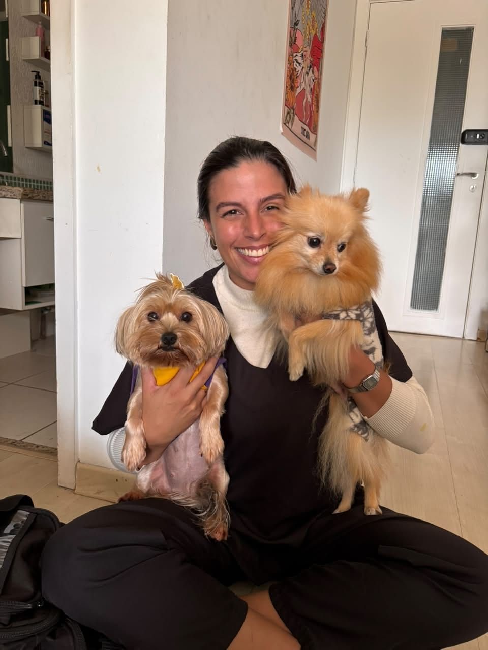 Dra. Thayná Iria com dois pets no colo, sorrindo